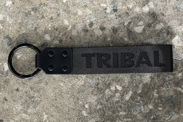 Black keychain with text on a concrete surface