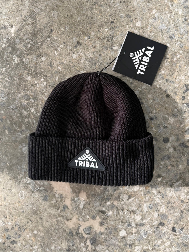 Black beanie with 'Tribal' logo on a concrete surface